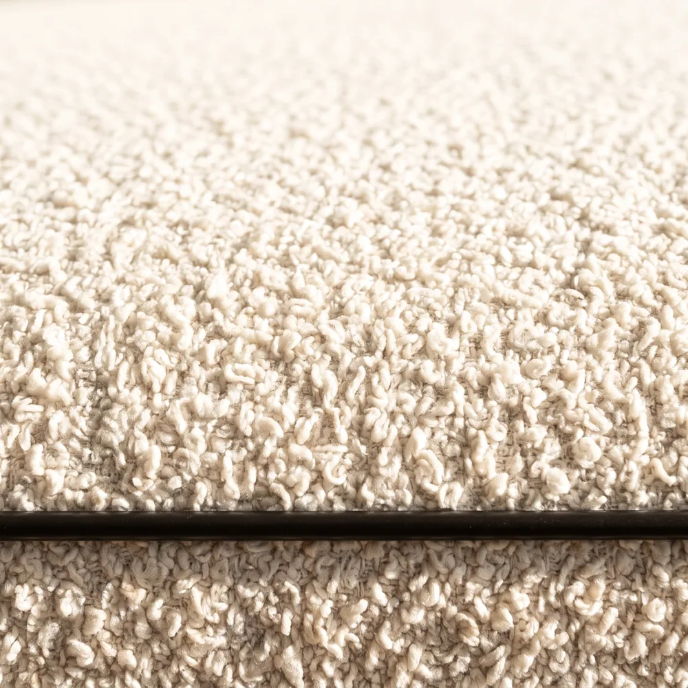 Cream bouclé cushions, the loops of the weave lit from the side
